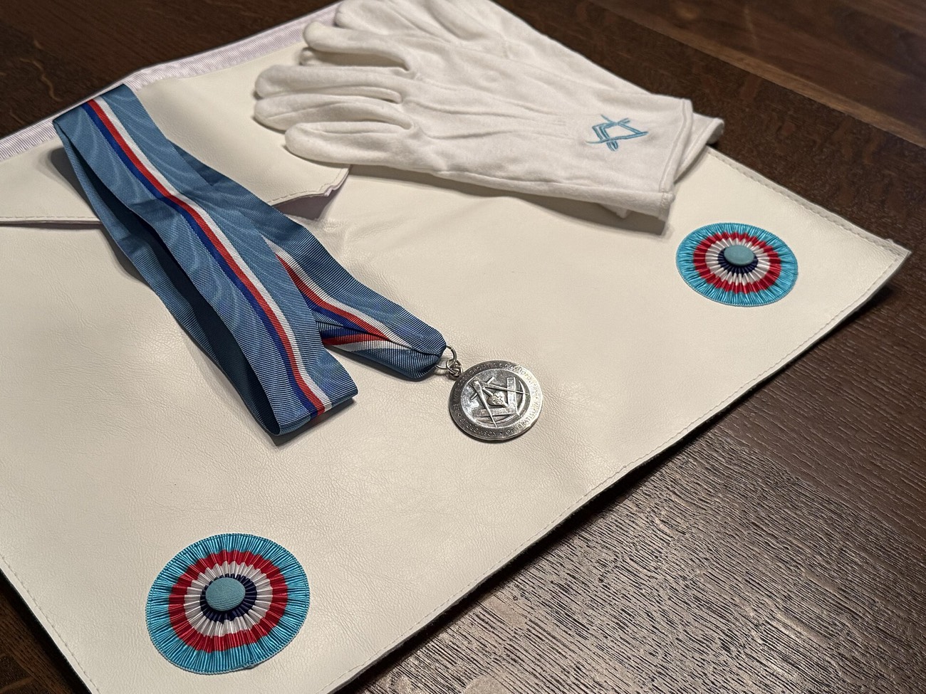 Masonic regalia: an apron, white gloves and a collar jewel